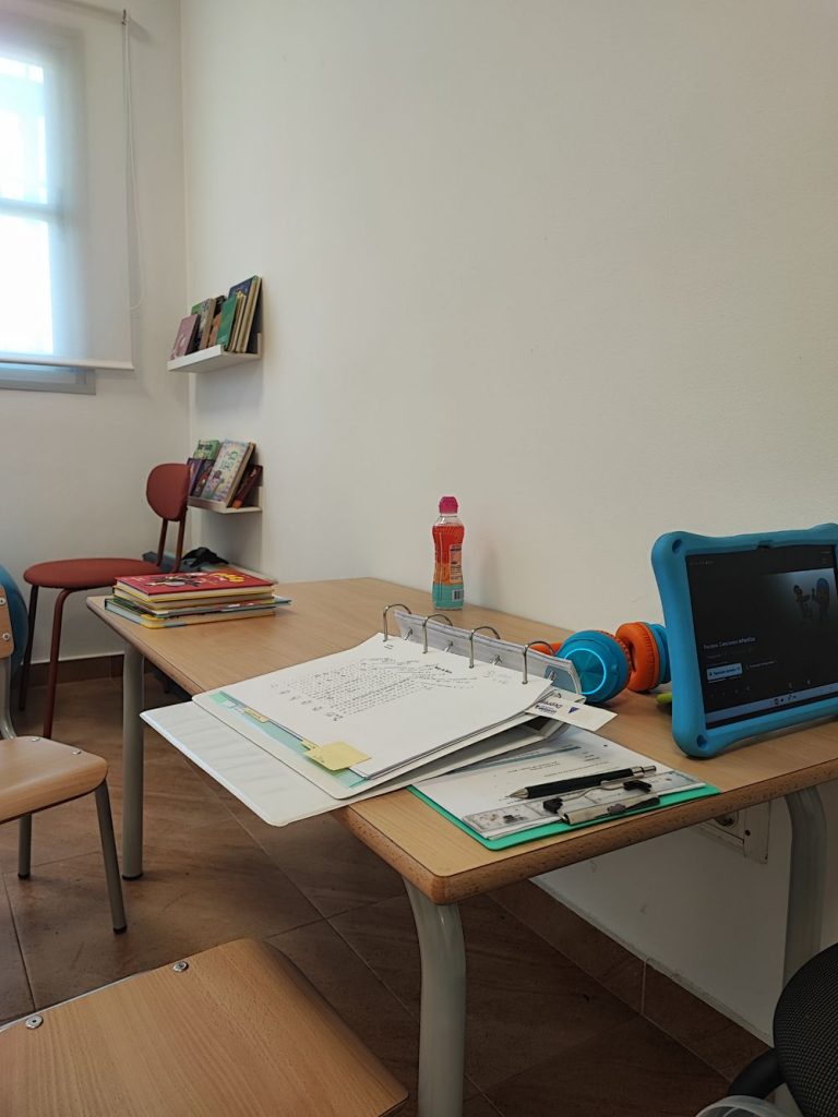 Sala de trabajo del centro con mesa, estantería de libros y ventana